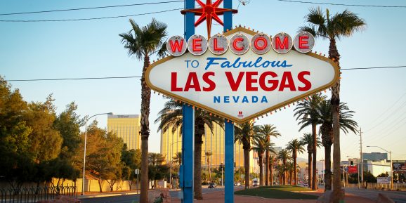 Jet Charter The iconic "Welcome to Fabulous Las Vegas Nevada" sign, illuminated by early morning sunlight with a clear blue sky and Las Vegas buildings in the background, can often be viewed from a private jet charter. Jetvia