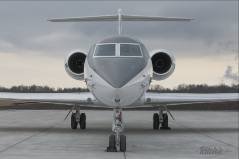 Jet Charter Front view of a white Private Jet Charter parked on a tarmac, showcasing its twin engines and sleek design under a cloudy sky. Jetvia