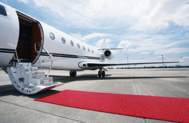 Jet Charter A private jet parked on an airport tarmac with a red carpet leading to its open cabin stairs, ready to serve increasing jet demand. Jetvia